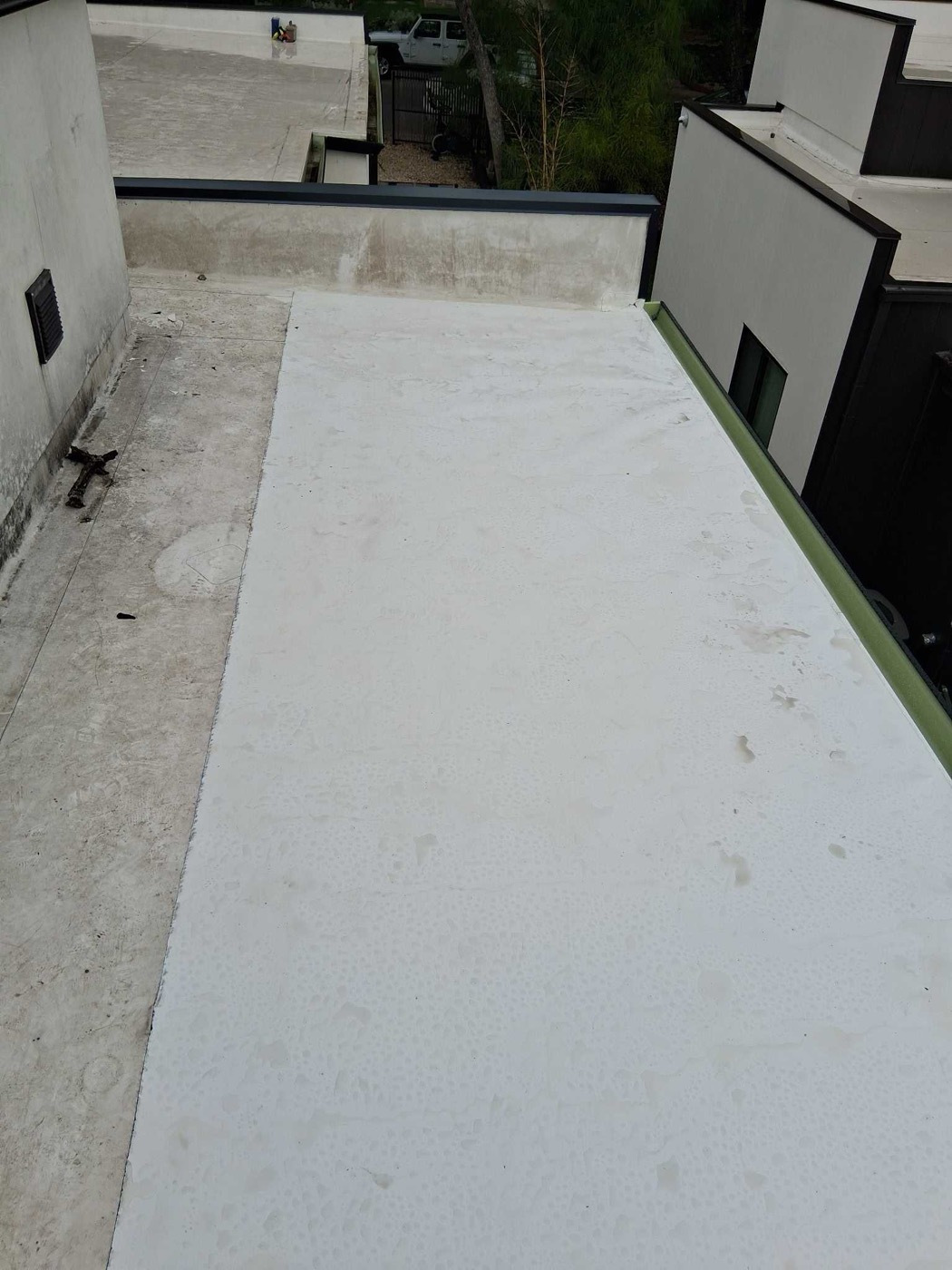 White TPO membrane finished on a rooftop deck in Austin with neighboring buildings visible