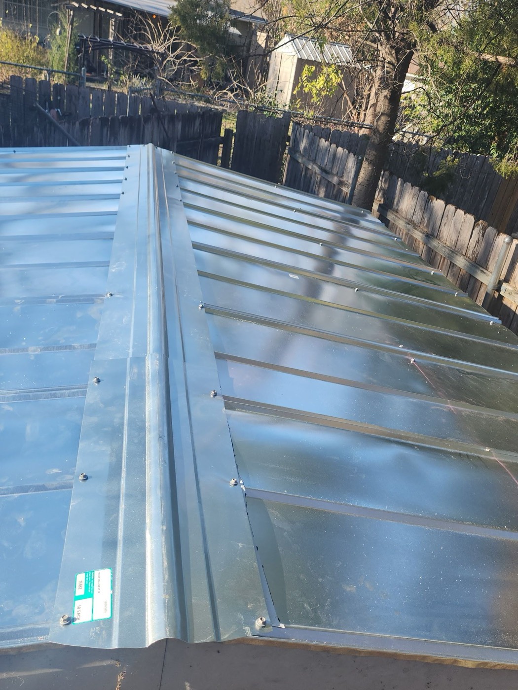New galvanized standing seam roof installed on a detached structure under the same insurance event as the main roof. Coverage B line approved when documented during the initial inspection.